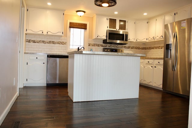 kitchen featuring backsplash, appliances with stainless steel finishes, white cabinets, and dark hardwood / wood-style flooring