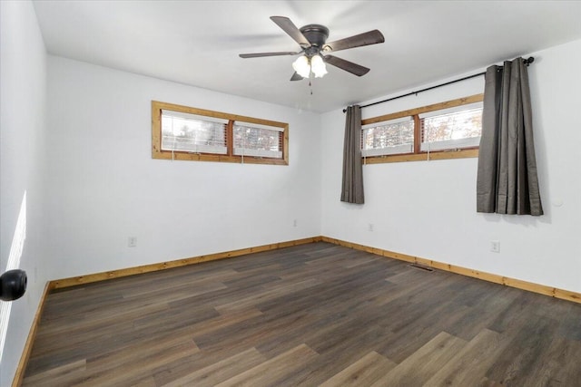 empty room with ceiling fan and dark hardwood / wood-style flooring