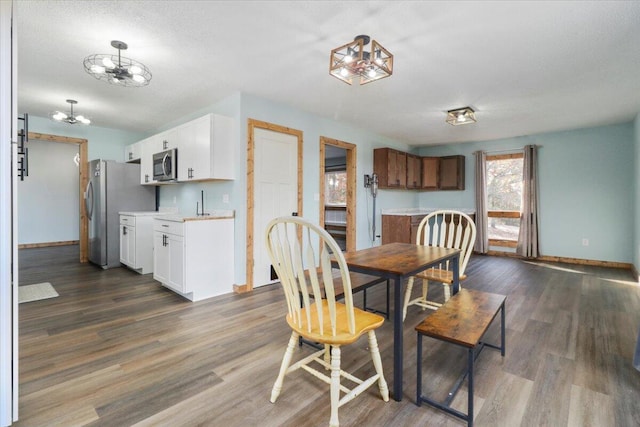 dining area featuring dark wood-type flooring and a textured ceiling