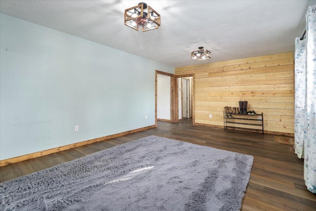 unfurnished room with a textured ceiling and dark wood-type flooring