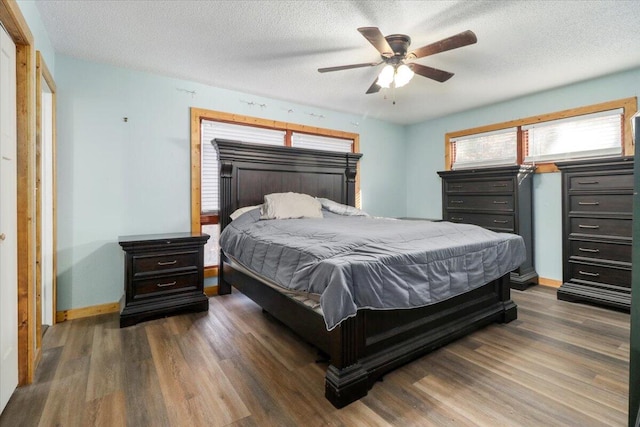 bedroom with dark wood-type flooring, ceiling fan, and a textured ceiling