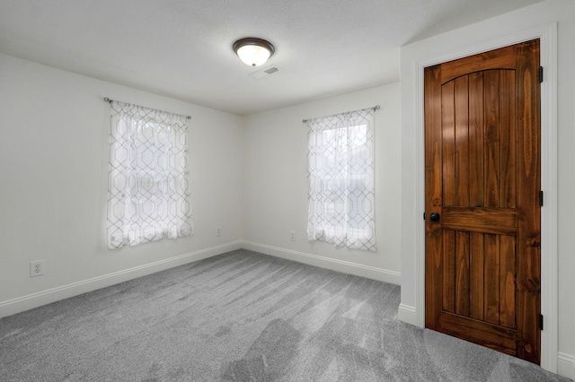 spare room featuring carpet and a textured ceiling