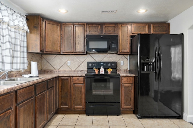 kitchen with sink, black appliances, decorative backsplash, and light tile patterned floors