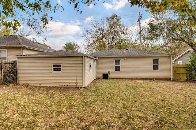 back of property featuring central air condition unit and a yard