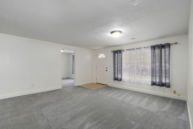 unfurnished living room featuring a textured ceiling and carpet floors