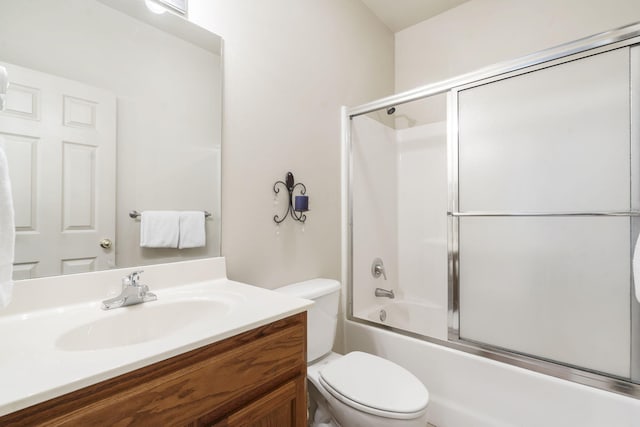 full bathroom with vanity, bath / shower combo with glass door, and toilet