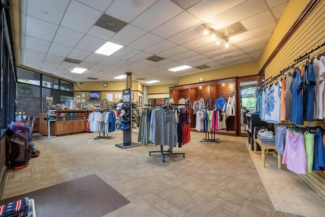 gym with light carpet and a paneled ceiling