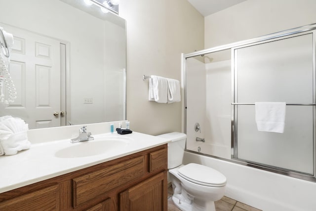 full bathroom with toilet, bath / shower combo with glass door, vanity, and tile patterned flooring