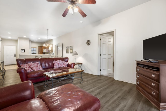 living room with hardwood / wood-style flooring and ceiling fan with notable chandelier