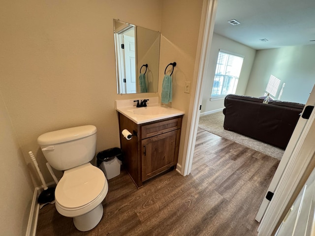 bathroom featuring toilet, hardwood / wood-style floors, and vanity