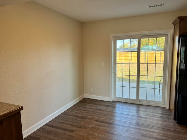 spare room featuring dark wood-type flooring and lofted ceiling