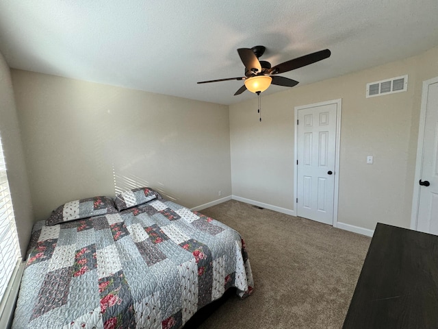 carpeted bedroom featuring ceiling fan and a textured ceiling