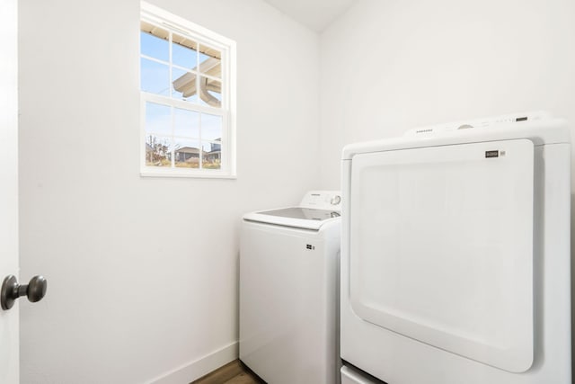 laundry room with washing machine and dryer and hardwood / wood-style flooring