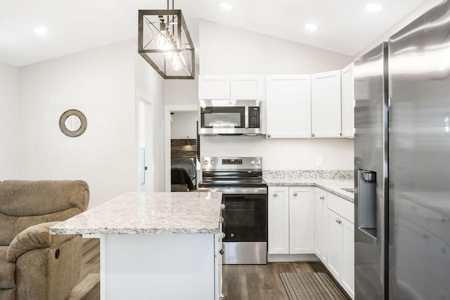 kitchen featuring appliances with stainless steel finishes, white cabinets, hanging light fixtures, and vaulted ceiling