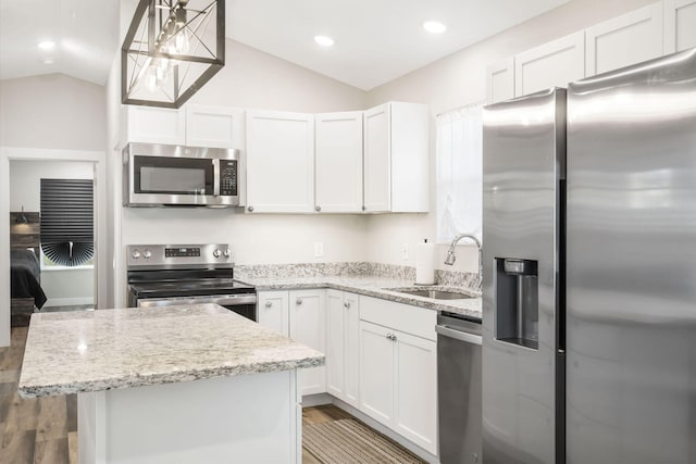 kitchen with white cabinetry, stainless steel appliances, sink, and vaulted ceiling