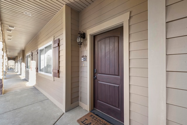 view of exterior entry featuring covered porch