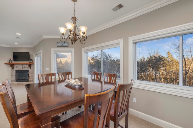 carpeted dining area featuring crown molding, a stone fireplace, and a chandelier