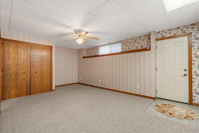 unfurnished bedroom featuring a closet, ceiling fan, carpet flooring, and a drop ceiling