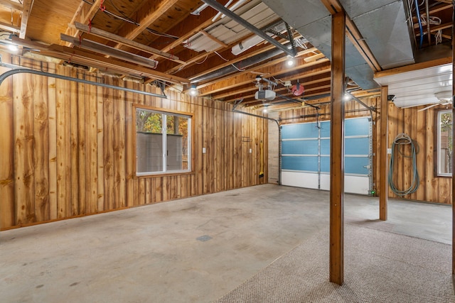 garage featuring a garage door opener and wooden walls