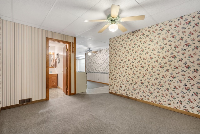 spare room with ceiling fan, light carpet, and a drop ceiling