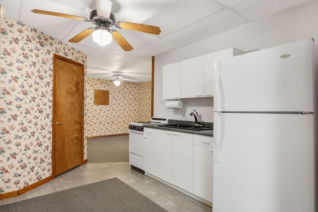 kitchen featuring sink, a drop ceiling, white cabinets, and white appliances