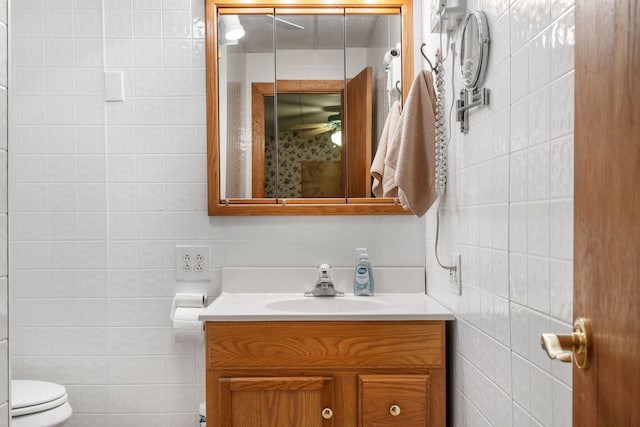 bathroom with tile walls, vanity, backsplash, and toilet