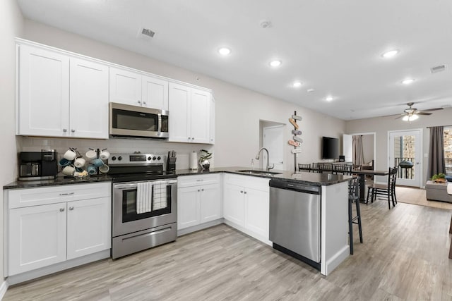 kitchen featuring white cabinetry, appliances with stainless steel finishes, sink, and kitchen peninsula