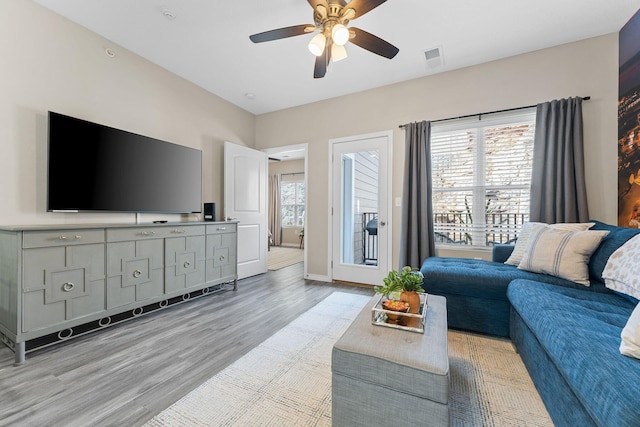 living room featuring light hardwood / wood-style flooring, a wealth of natural light, and ceiling fan