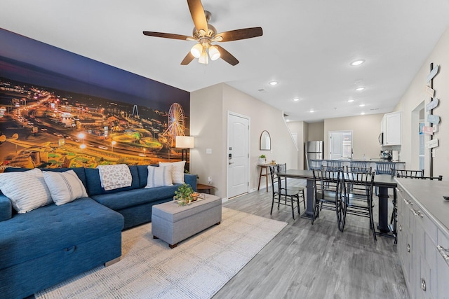 living room with light wood-type flooring and ceiling fan