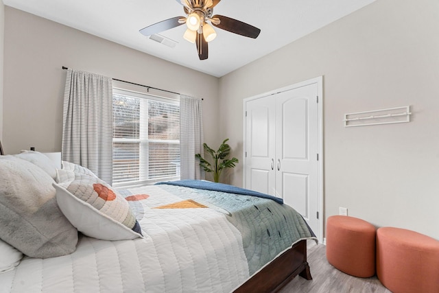 bedroom with a closet, wood-type flooring, and ceiling fan