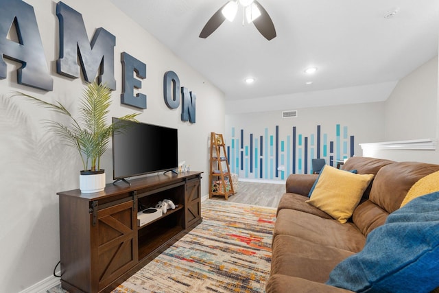 living room featuring lofted ceiling, hardwood / wood-style flooring, and ceiling fan