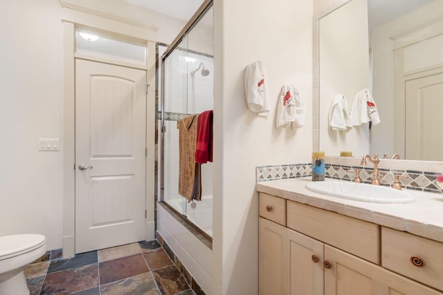 full bathroom featuring vanity, toilet, and shower / bath combination with glass door