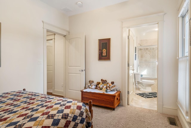 bedroom featuring ensuite bath and light colored carpet