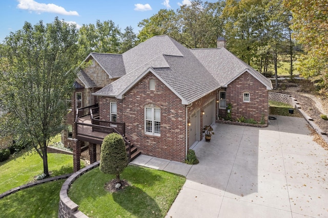 view of front of home featuring a front yard, a wooden deck, and a garage