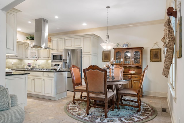 dining space with ornamental molding and light tile patterned floors