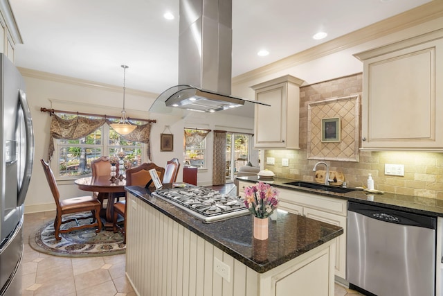 kitchen with island exhaust hood, appliances with stainless steel finishes, dark stone counters, cream cabinetry, and sink