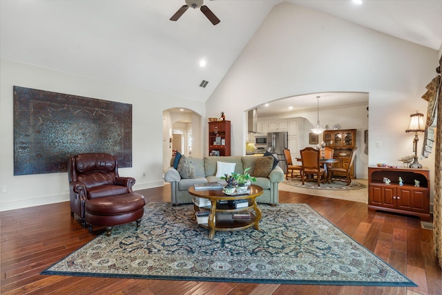 living room with dark hardwood / wood-style floors, high vaulted ceiling, and ceiling fan with notable chandelier