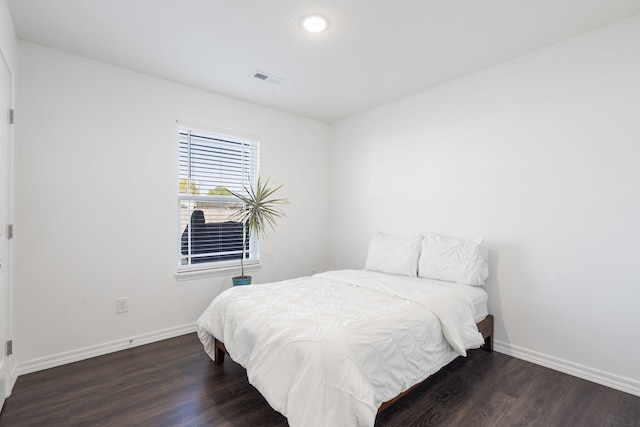 bedroom with dark wood-type flooring