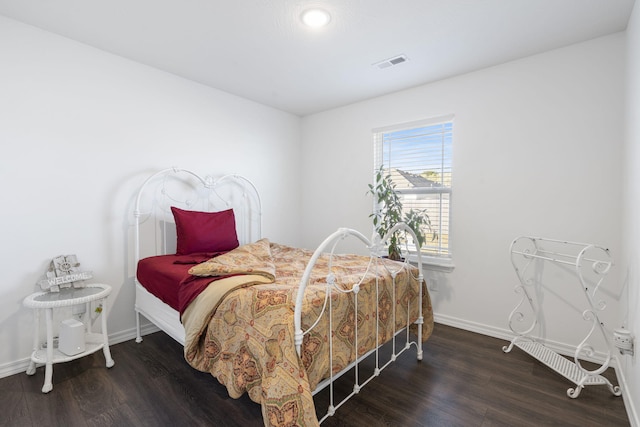 bedroom with dark hardwood / wood-style floors