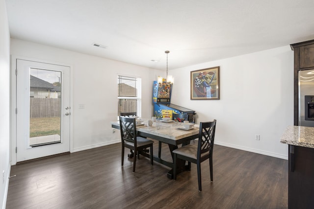 dining space featuring a notable chandelier and dark hardwood / wood-style floors