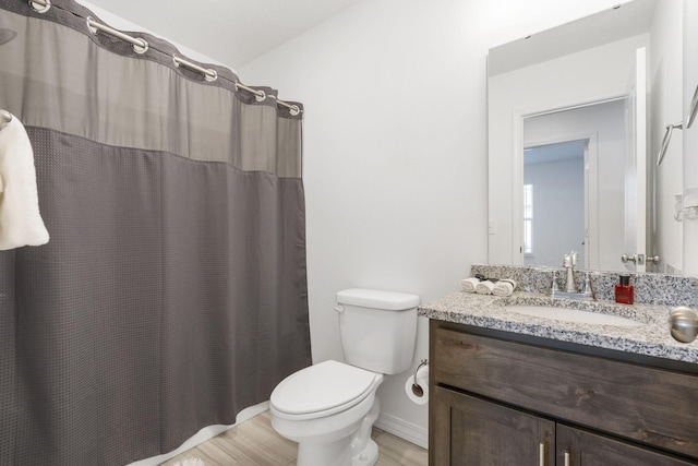 bathroom featuring vanity, hardwood / wood-style floors, a shower with curtain, and toilet