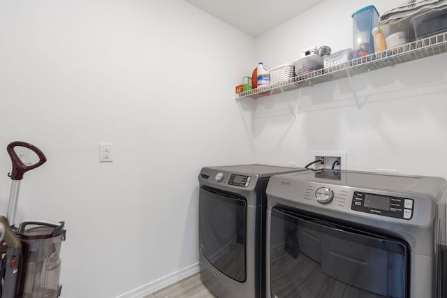 clothes washing area featuring hardwood / wood-style flooring and washing machine and dryer