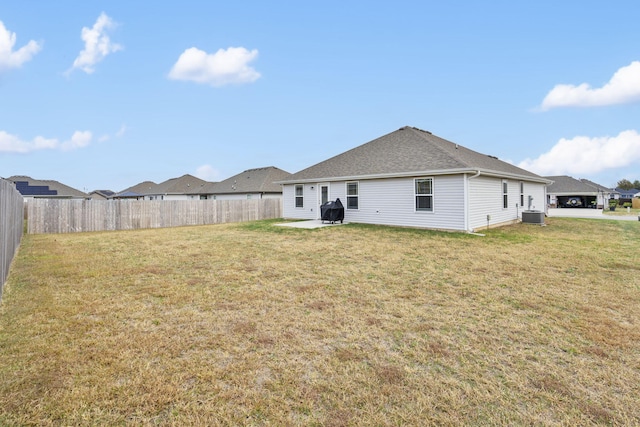 rear view of house with a yard and central air condition unit