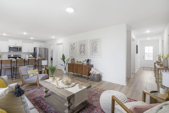 living room with sink and light wood-type flooring