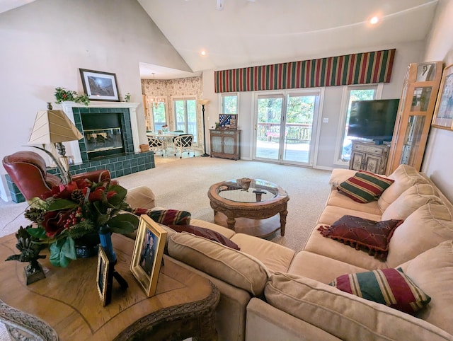 carpeted living room with a tiled fireplace and high vaulted ceiling