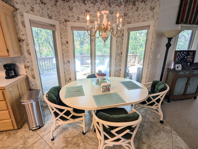 dining area with an inviting chandelier, light tile patterned flooring, and plenty of natural light