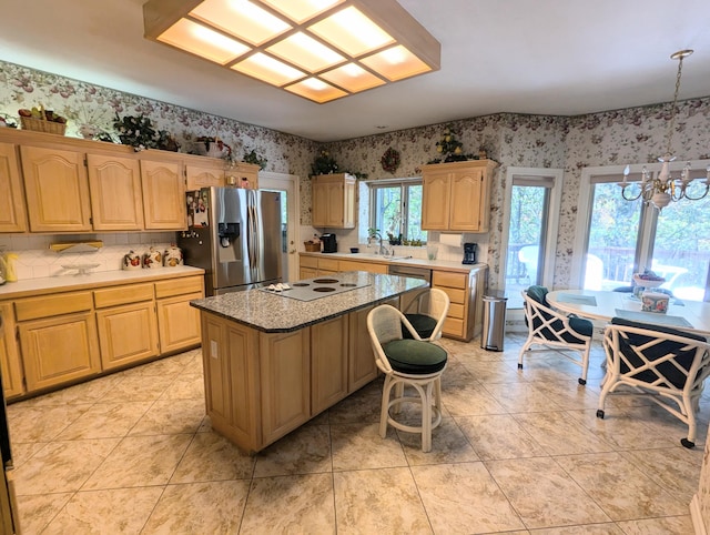 kitchen with a notable chandelier, a center island, a healthy amount of sunlight, and stainless steel fridge with ice dispenser