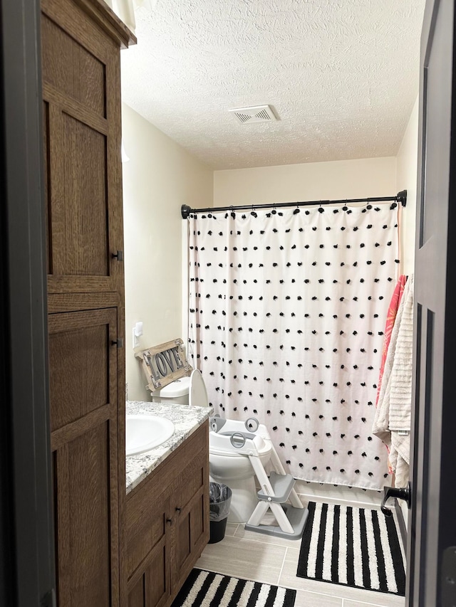 bathroom with vanity, toilet, a textured ceiling, and a shower with shower curtain