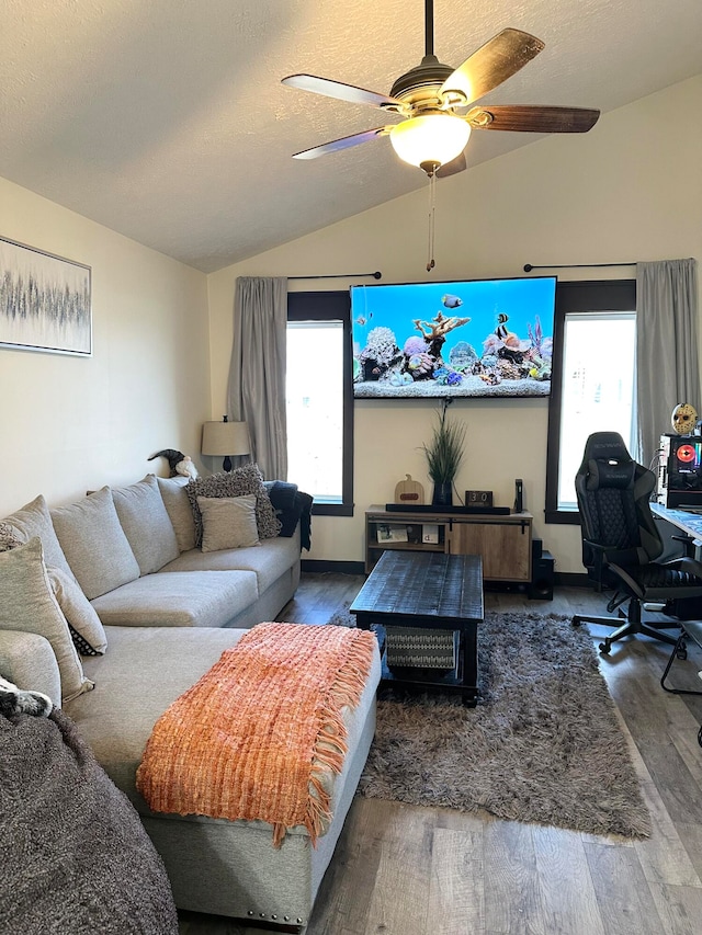 living room featuring ceiling fan, wood-type flooring, lofted ceiling, and a wealth of natural light