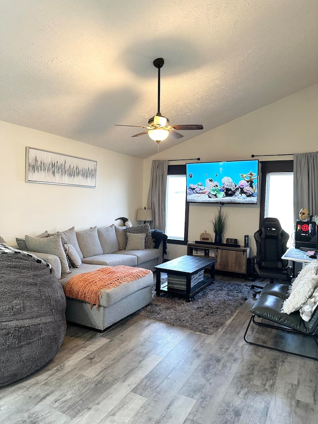 living room featuring lofted ceiling, hardwood / wood-style flooring, ceiling fan, and a wealth of natural light